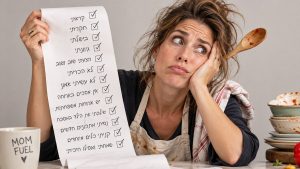 אמא עייפה מחזיקה צ'ק ליסט ארוך שכל השורות בו מסומנות, עם עיפרון מאחורי האוזן